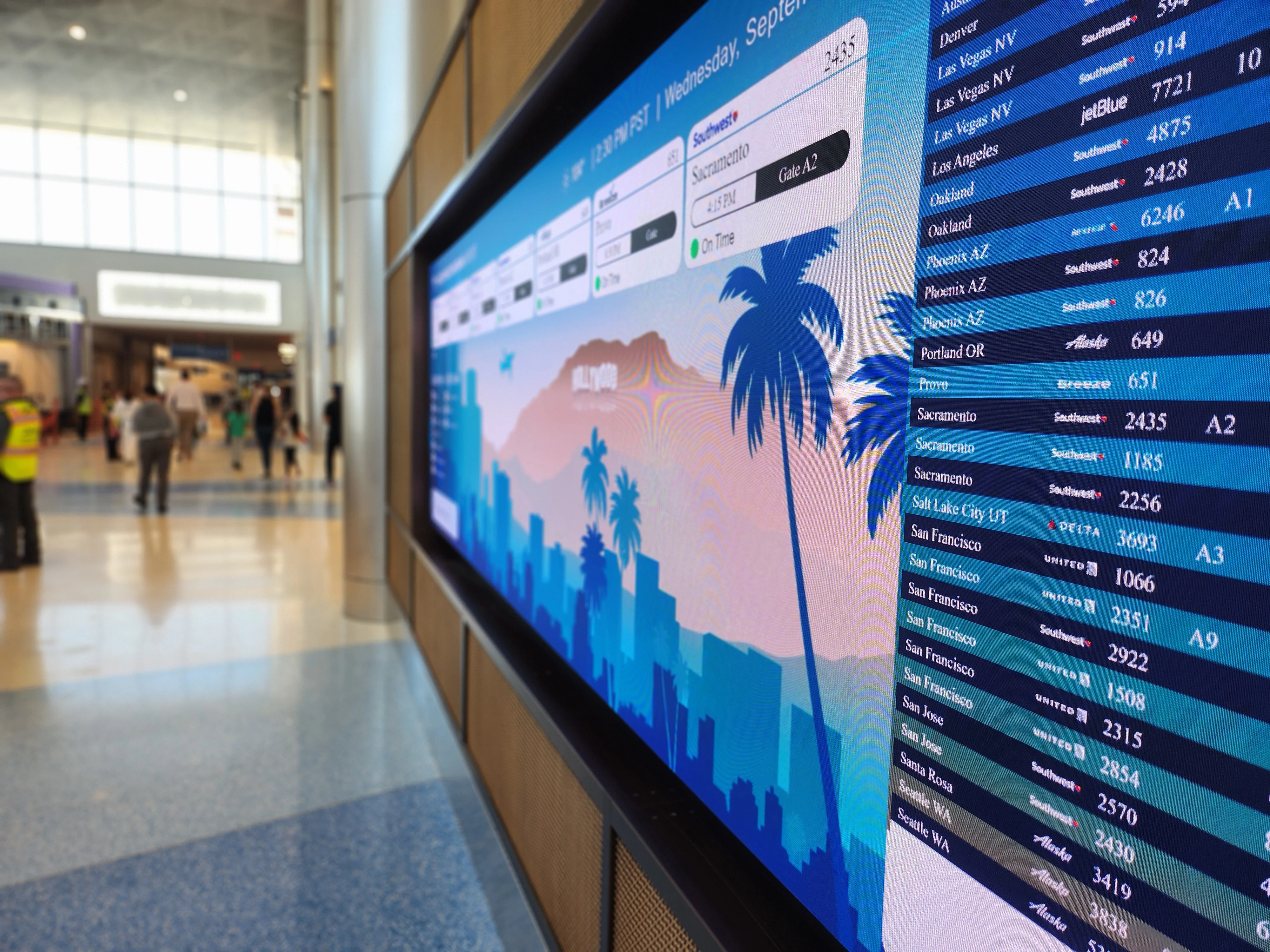 A large flight information monitor displaying arrivals and departures